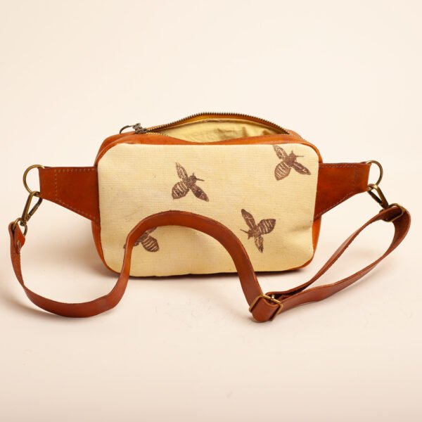 a fanny pack in leather and yellow canvas printed with bees
